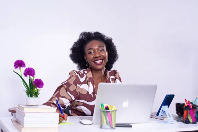 Businesswoman smiling while working on a laptop at her desk